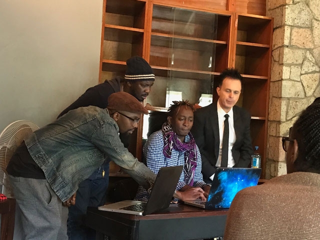 Eric Wainaina and other creative artists discussing a piece